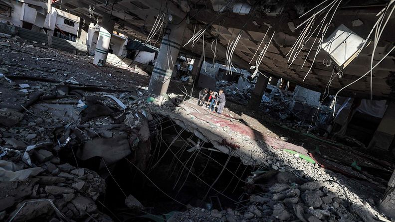 Lapset katsoivat Israelin pommituksissa tuhoutuneen moskeijan katon läpi Rafahissa, Gazassa, 14. helmikuuta 2024.