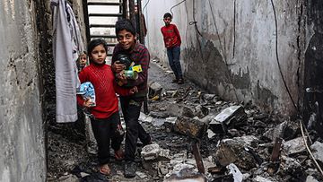 Lapsia kulki romun täyttämällä kujalla Israelin öisten pommitusten jälkeen Rafahissa, Gazassa, 25. helmikuuta 2024.