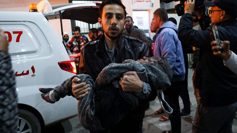 Palestiinalaismies kantoi pahoin loukkaantunutta lasta Kuwaitin sairaalaan Rafahissa, Gazassa 26. helmikuuta 2024.