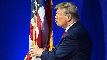 Republikaanien presidenttiehdokkuutta tavoitteleva Donald Trump suuteli Yhdysvaltojen lippua konservatiivipoliitikkojen konferenssissa 24. helmikuuta 2024.