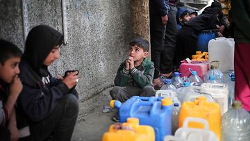 Palestiinalaislapset kerääntyvät vesisäiliöiden ympärille Rafahissa Gazan eteläosassa 1. maaliskuuta 2024 Israelin ja palestiinalaisen