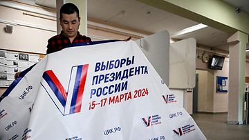 LK 14.3.2024 Vapaaehtoinen valmistelee äänestyspaikkaa ennen presidentinvaaleja Moskovassa 14. maaliskuuta 2024.