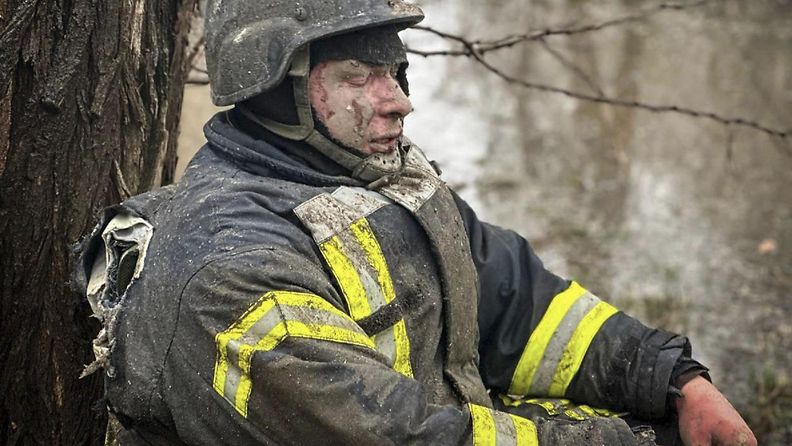 Loukkaantunut ukrainalainen pelastustyöntekijä istui puun juurella Venäjän ohjusiskujen jälkeen Odessassa 15. maaliskuuta 2024.