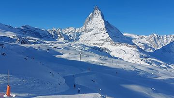 Laskettelijoita Zermattin laskettelualueella Sveitsissä joulukuussa 2023. Taustalla Matterhorn-vuori.