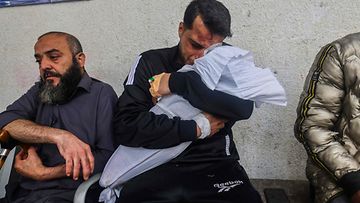 Palestiinalainen isä halaa toisen Israelin ilmaiskussa kuolleen tyttärensä käärittyä ruumista Rafahissa 4. huhtikuuta 2024.