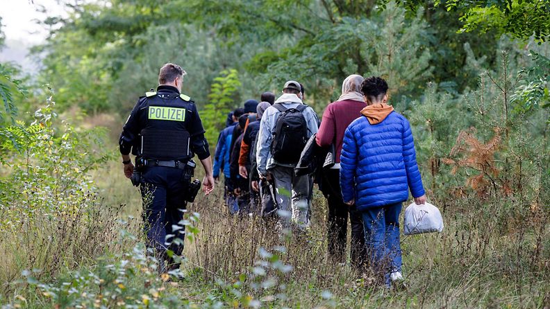 LK 10.4.2024 Saksan liittovaltion poliisin upseeri saattaa maahanmuuttajaryhmää Forstin lähellä Itä-Saksassa 11. lokakuuta 2023 partioidessaan lähellä Puolan rajaa.