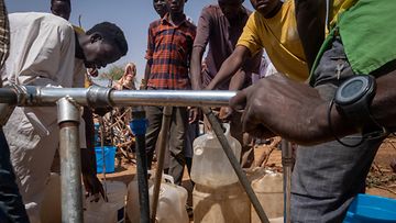 Sudanilaisia pakolaisia hakemassa kaivosta vettä.
