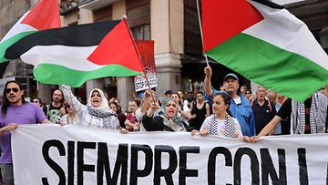 Mielenosoittajat heiluttavat Palestiinan lippuja Madridissa.