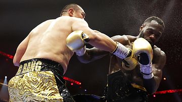 Deontay Wilder (oik.) koki kovia Zhilei Zhangin käsittelyssä. 