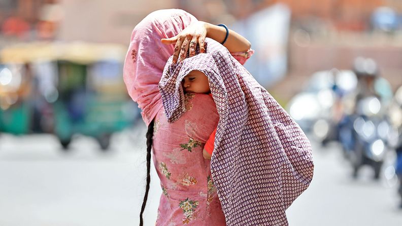 Nainen suojasi vauvaansa kankaalla helleaallon kuumuudessa Jaipurissa, Intiassa 25. toukokuuta 2024.