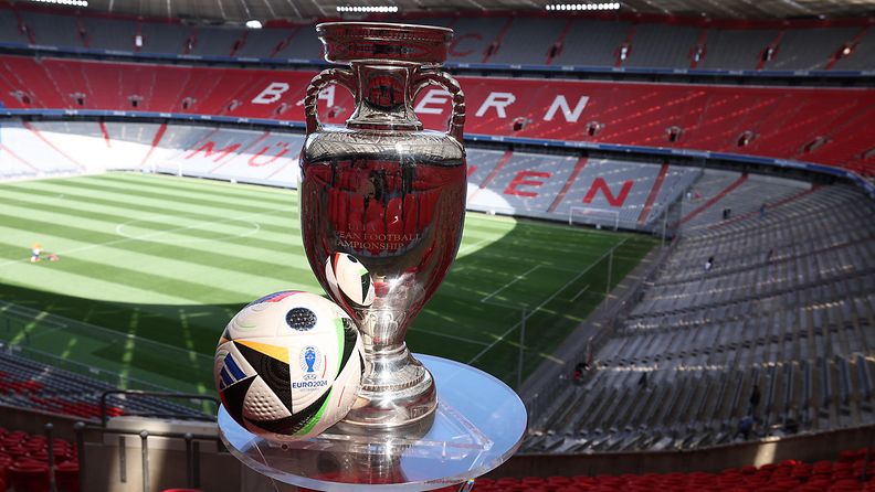 Jalkapallon EM-kisojen voittopokaali ja vuoden 2024 turnauksen virallinen pallo kuvattuna Münchenissä Allianz Arena, joka toimii yhtenä EM-kisojen pelipaikoista. 
