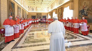 Paavi Franciscus ja joukko kardinaaleja Vatikaanissa.