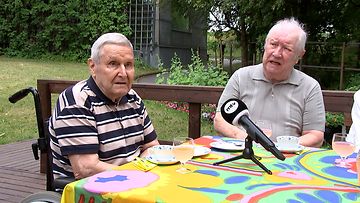 Foibekartanon asukkaat Seppo Auvinen ja Nils Mattlin istuvat kahvipöydän ääressä ulkona.