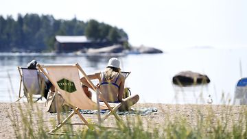 Ihmiset nauttivat lämpimästä päivästä Lauttasaaren uimarannalla Helsingissä 21. heinäkuuta 2022.