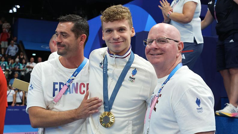 Leon Marchand (kesk.) oli Pariisin kisojen kuningas. Valmentaja Bob Bowman (oik.) on tuttu mies myös Michael Phelpsin menestyksen takaa.