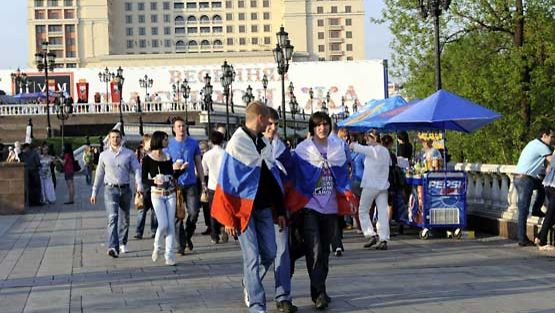 Paikallisia Venäjän lippujen kanssa Moskovan keskusaukiolla.